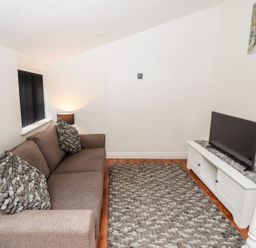 A living room with a sofa and television at Bobby's in Whitby