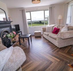 A living room with a sofa and a television at Ard Na Mara in 