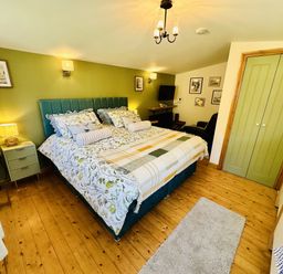 A bedroom with a bed and bedside table at Harvey's Lodge in Lowertown, Helston