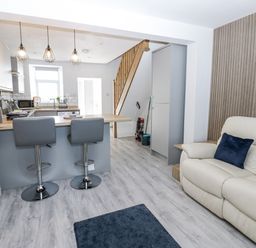 A living room with stools and kitchen area at Keekle Terrace in Cleator Moor