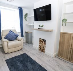 A living room with an armchair and television at Keekle Terrace in Cleator Moor