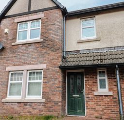 A house exterior with a green door and brick walls at Lingla House in Frizington