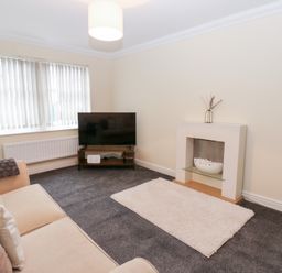 A living room with a television and sofa at Lingla House in Frizington
