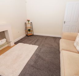A living room with a sofa and a fireplace at Lingla House in Frizington