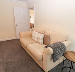 A living room with a sofa and side table at Lingla House in Frizington