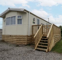 A mobile home with wooden steps in St Bees at Puffin