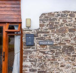 Exterior view of Church Barn with window and stone wall in Sutcombe near Bradworthy