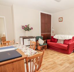 A living room with a sofa and table at Kate's Cottage