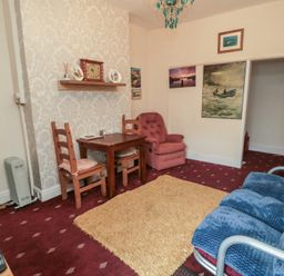 A living room with a table and chairs at 170 Victoria Road