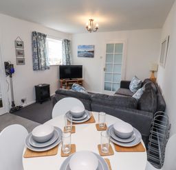 A living room with a sofa and dining table at 51 Longstone Park