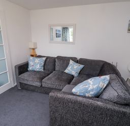 A living room with a sofa and lamp at 51 Longstone Park