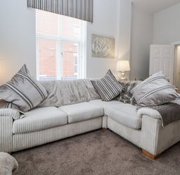 A living room with a sofa and lamp at No 2 Emporium Apartments in Prestatyn