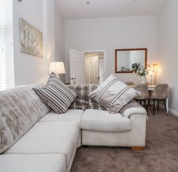 A living room with a sofa and a dining table at No 2 Emporium Apartments Prestatyn