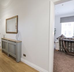 A hallway with a console table and a view of a living room at No 2 Emporium Apartments in Prestatyn