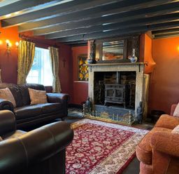 A living room with sofas and a fireplace at St. James Cottage in Liskeard