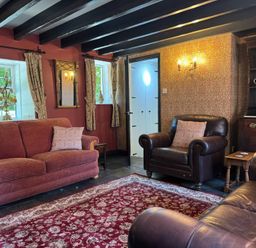 A living room with sofas and a rug at St. James Cottage in Liskeard