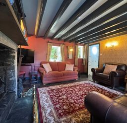 A living room with a sofa and armchair at St. James Cottage Liskeard