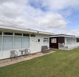 A view of a property with seating area and multiple cabins at 66 Cherry Park in Skegness