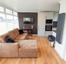 A living room with a sofa and television at 66 Cherry Park in Skegness