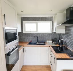 A kitchen with an oven and sink at 66 Cherry Park in Skegness