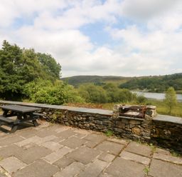 An outdoor area with a table and seating at Ty Newydd in Llanrhychwyn near Llanrwst