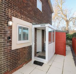 An entrance with a conservatory and paved pathway at Seaspray in Beadnell