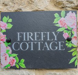A sign with the name Firefly Cottage at Firefly Cottage