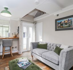 A living room with a bar counter and seating at Firefly Cottage
