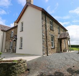 A house with stone exterior and patio area at The Sycamores in Llawhaden near Narberth