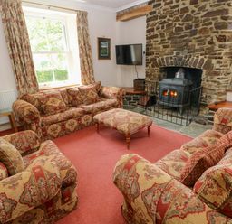 A living room with a fireplace and seating area at The Sycamores in Llawhaden near Narberth