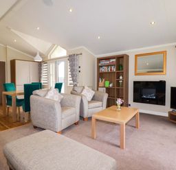 A living room with a sofa and dining area at The Maples 44 St. Austell