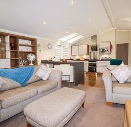A living room with a sofa and dining area at The Maples 44 St. Austell