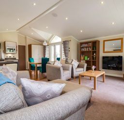 A living room with a sofa, chairs, and a table at The Maples 44 St. Austell