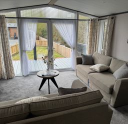 A living room with a sofa and sliding doors at Lime Tree Lodge
