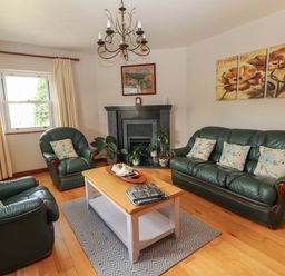 A living room with green sofas and a coffee table at Ash House in Ballyvaughan