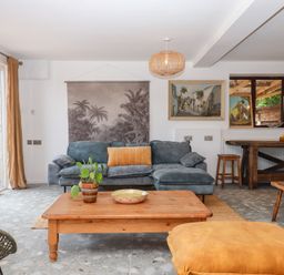 A living room with a sofa, coffee table, and artwork at Tigley Meadow Coach House in Totnes