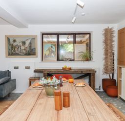 A dining room with a table and artworks at Tigley Meadow Coach House in Totnes