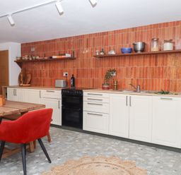 A kitchen with cabinets and dining area at Tigley Meadow Coach House in Totnes