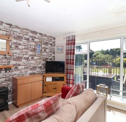 A living room with a television and a sofa at Boo’s Bungalow in Callington near Gunnislake