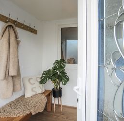A hallway with coat hooks and a plant at Penrhos Walks Holyhead