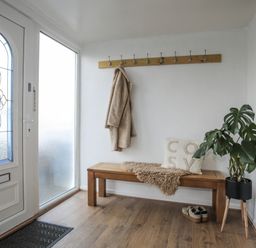 A hallway with a bench and coat hooks at Penrhos Walks in Holyhead