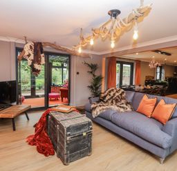 A living room with a sofa and television at Holly Farm near Brantham