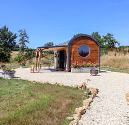 A house with a gravel path and flower pots at Bugley Pools Hideaway in Bugley near Gillingham