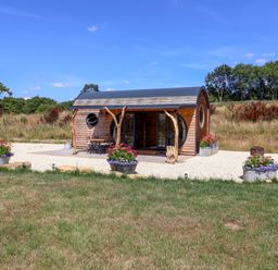 A cabin with outdoor seating and planters at Bugley Pools Hideaway Bugley near Gillingham