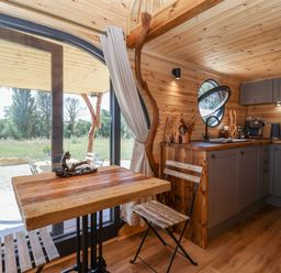 A kitchen with a table and stools at Bugley Pools Hideaway Bugley near Gillingham