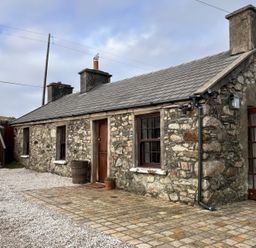 A stone cottage with paved area and steps at Cobble Stone Cottage near Leabgarrow, County Donegal