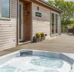 An outdoor area with a hot tub and seating at Two Tree Tops in Lanreath