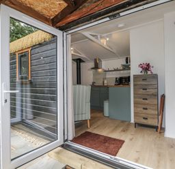 A kitchen with a view of the outside at Charltons Hollow Cabin in Haywards Heath