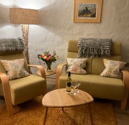 A living room with chairs and a table at Tamarisk Cottage in St Agnes
