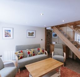 A living room with furniture and a staircase at Bluck's cottage St. Agnes